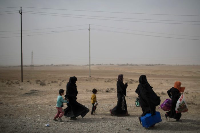People fleeing Islamic State held territory walk on a road near the last government controlled checkpoint south of Mosul, Iraq, Tuesday, Nov. 1, 2016. (AP Photo/Felipe Dana)